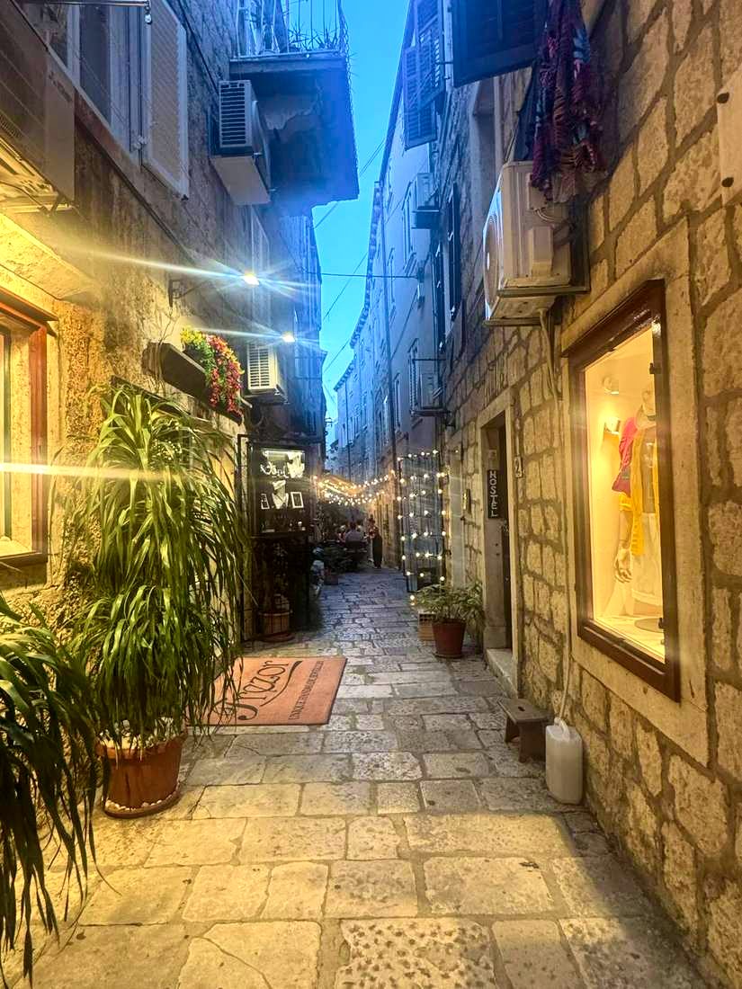 An empty lane at blue hour, string lights going on